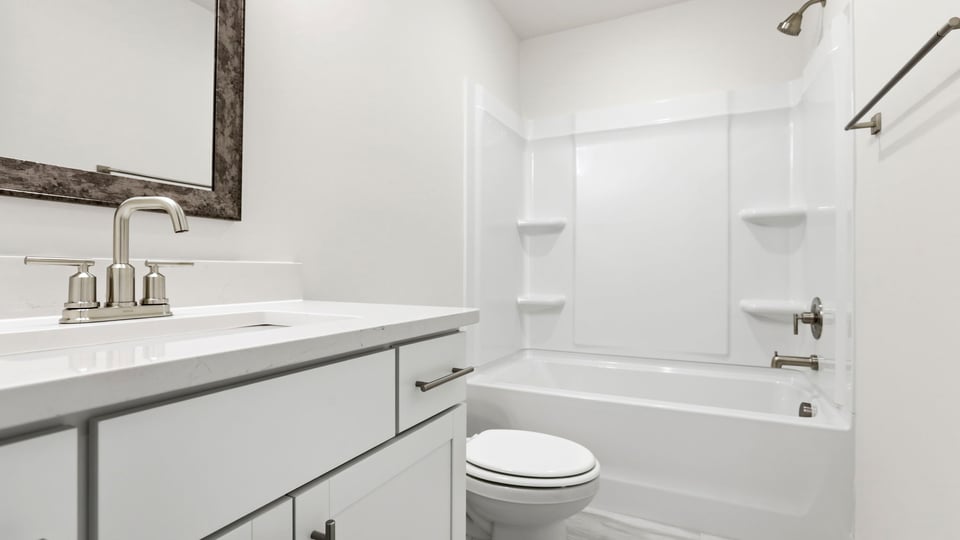 Upper-level bathroom with vanity and combination shower / tub.