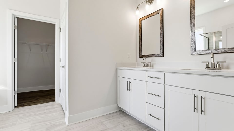 Primary bathroom with dual sink vanity and mirrors.