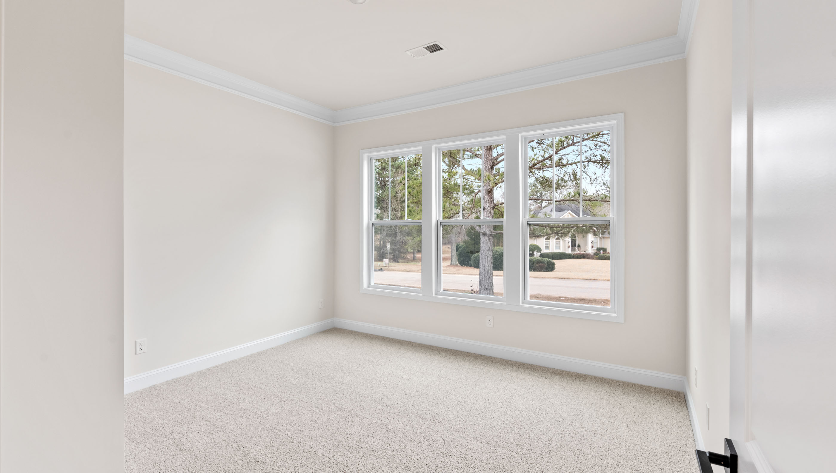 Bedroom with carpet and  windows.