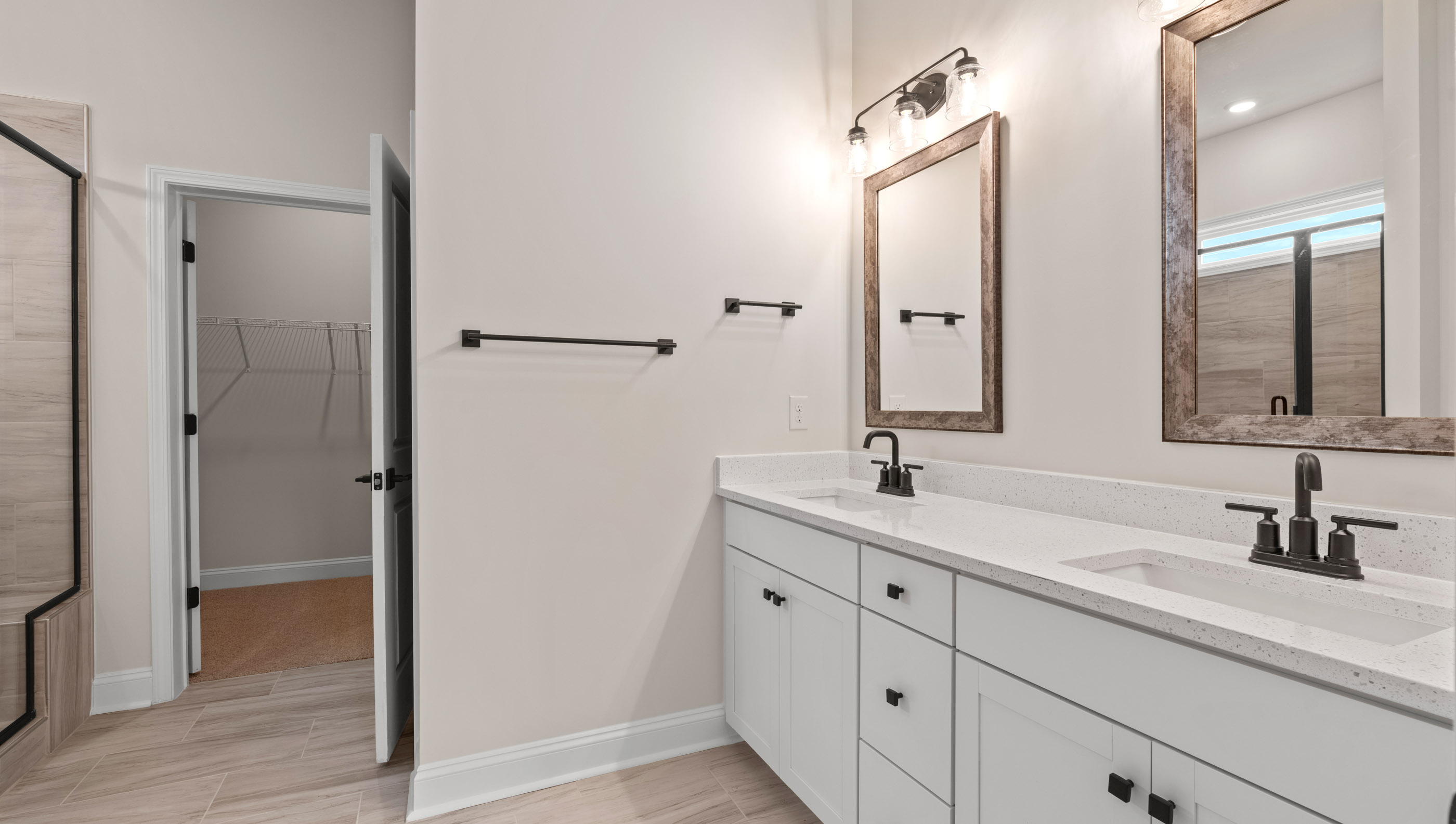 Bathroom with double vanity sink and walk in closet.