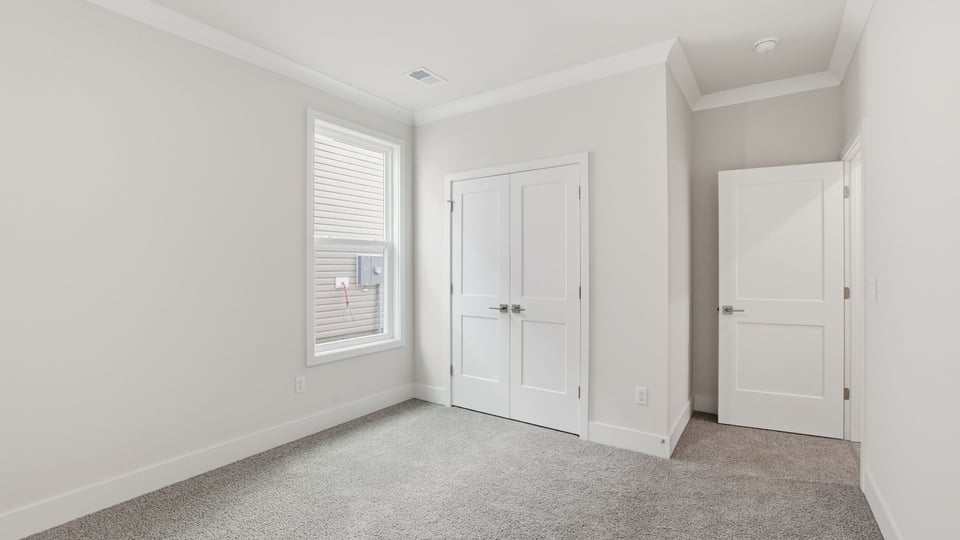 Bedroom with window and carpet.