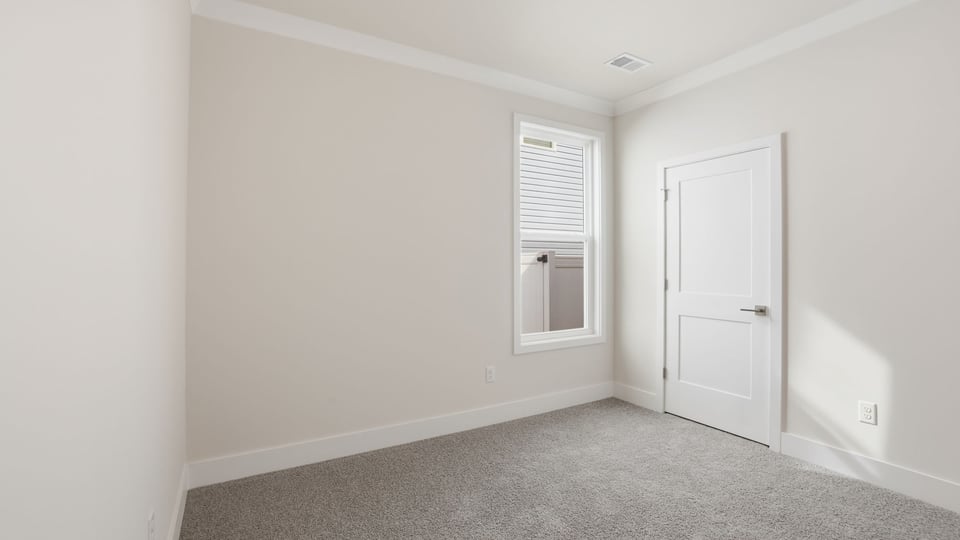 Bedroom with window and carpet.
