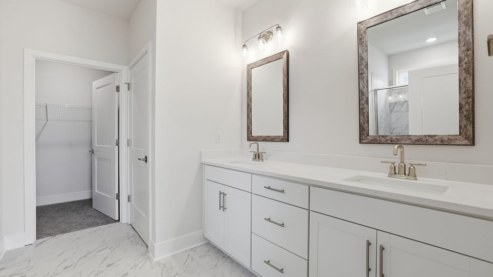 Primary bathroom with dual sink vanity and mirrors.