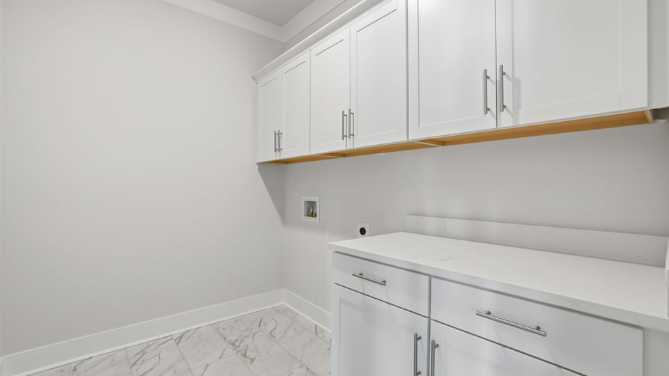 Walk-in laundry room with cabinets.