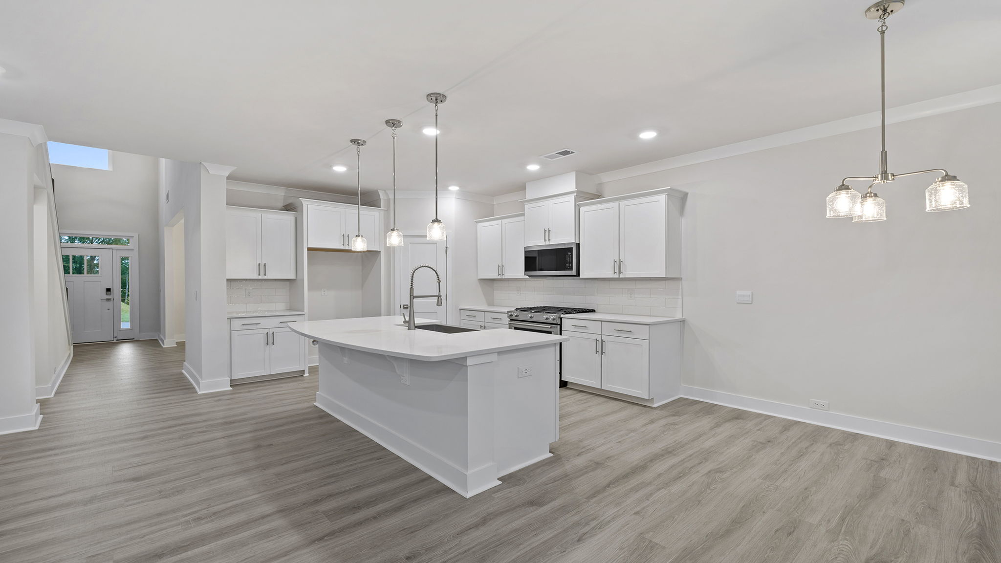 Kitchen has pendulum lighting.