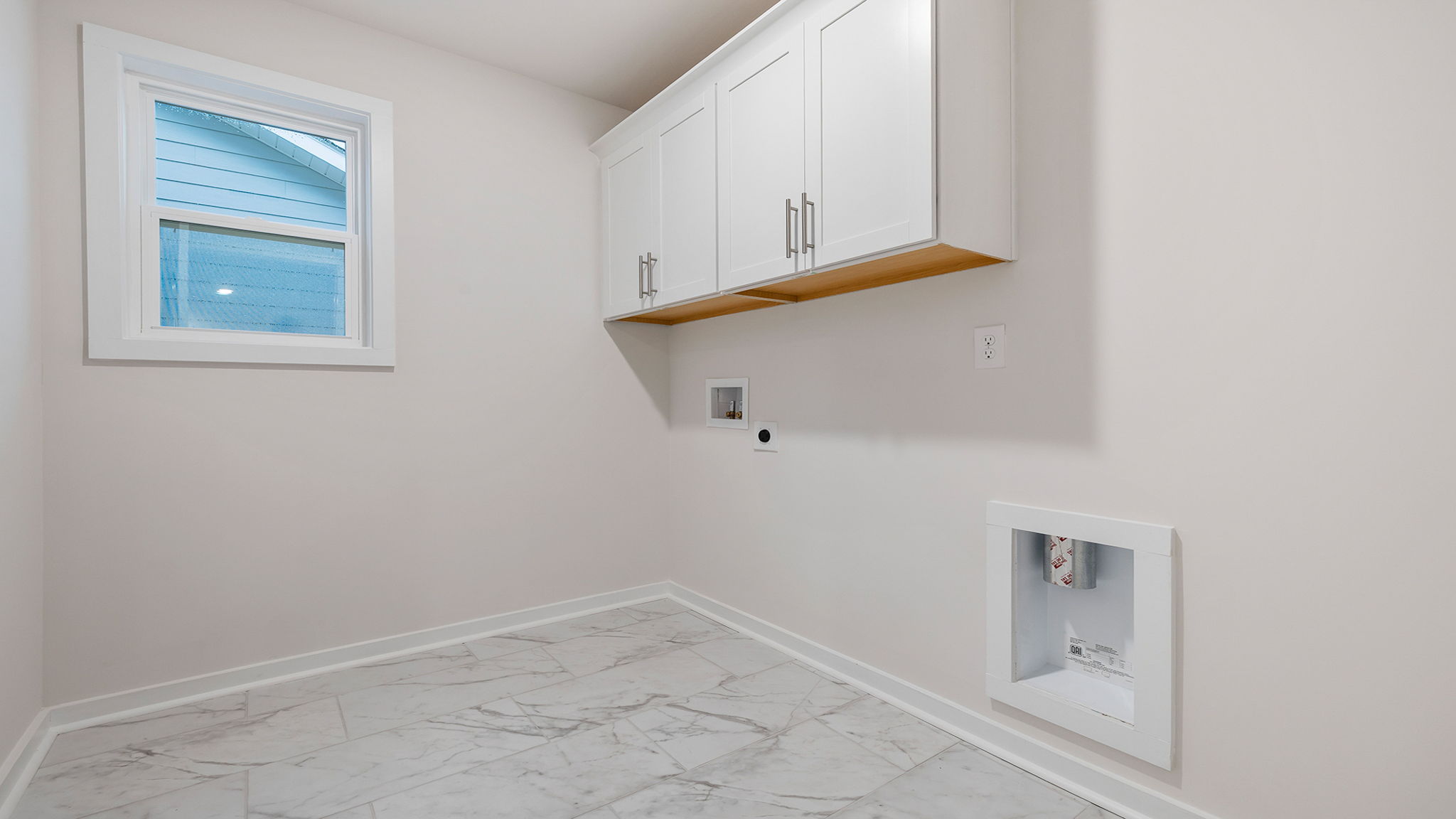 Walk in laundry room with cabinets.