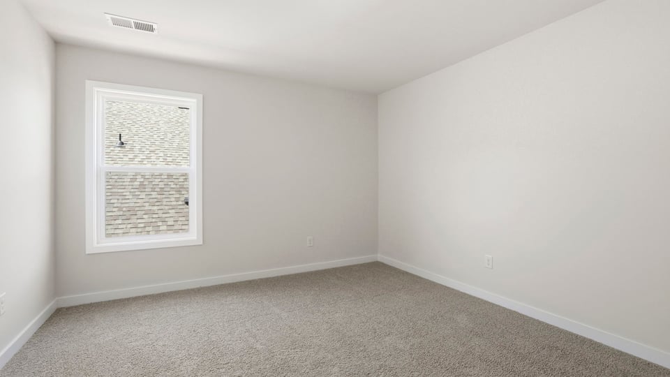 Bedroom with carpet and window.