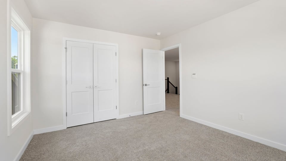 Bedroom with carpet and window.