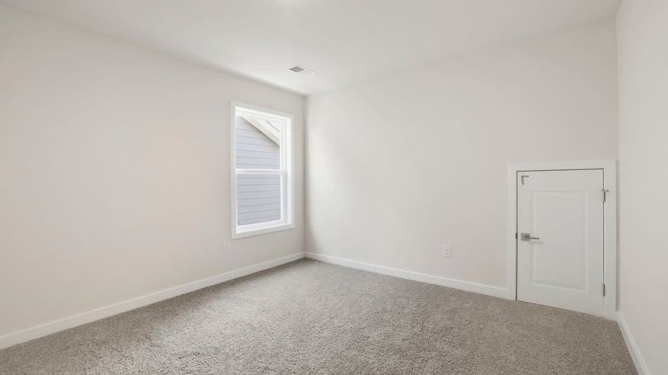 Bedroom with carpet and window.