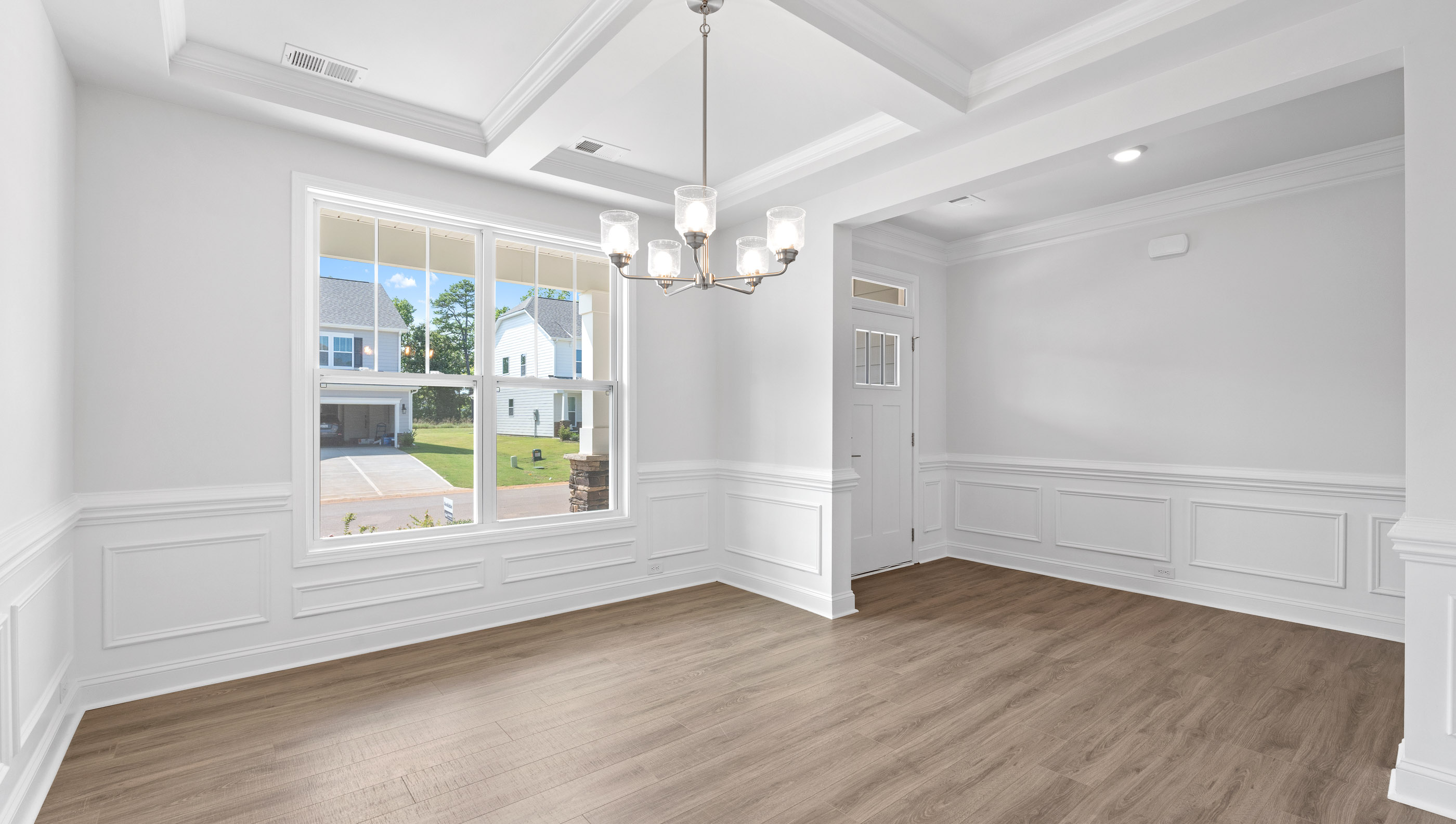 Formal dining room with coffered ceilings at the front of the home.