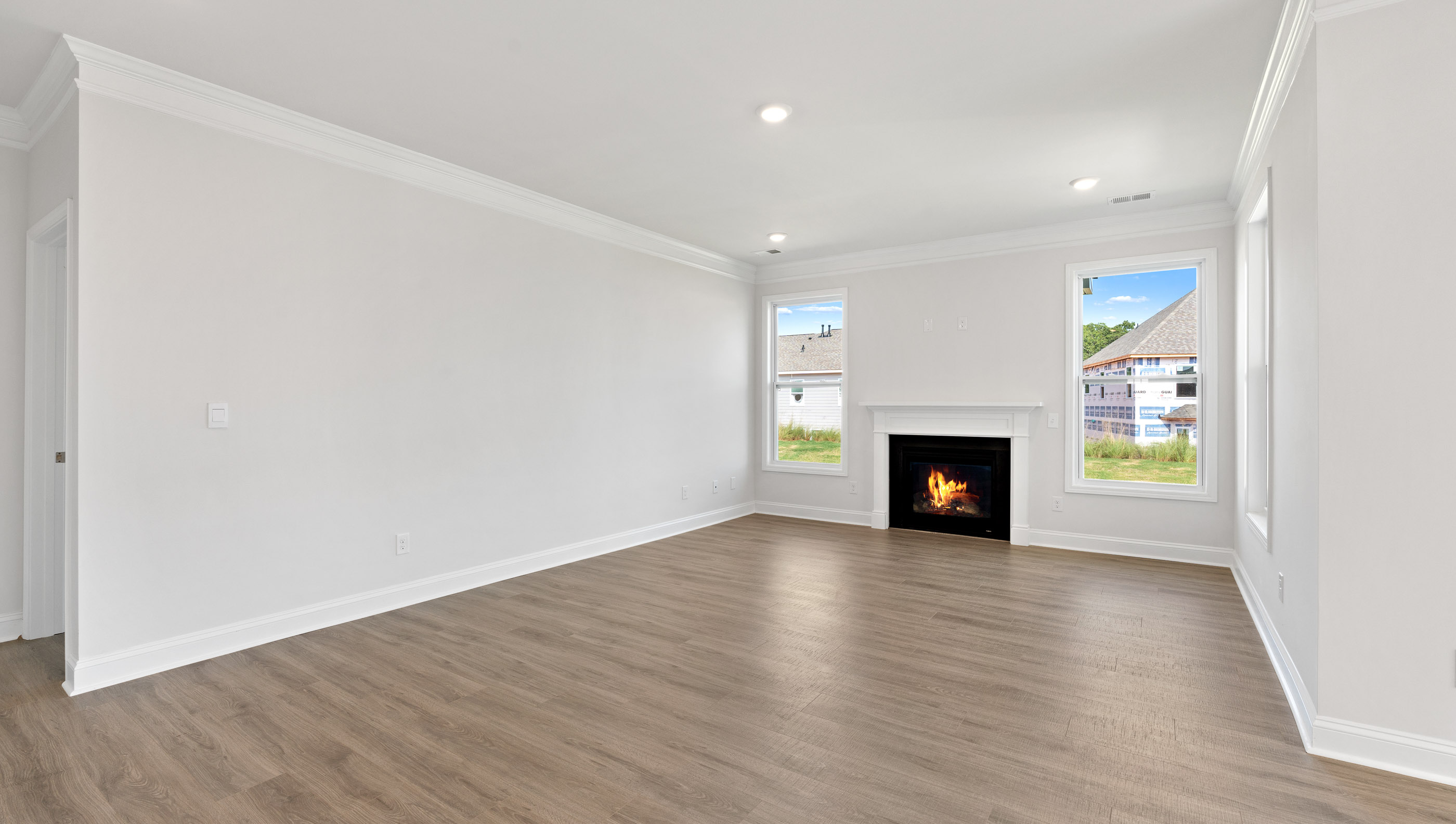 Family room with two windows and gas log fireplace.