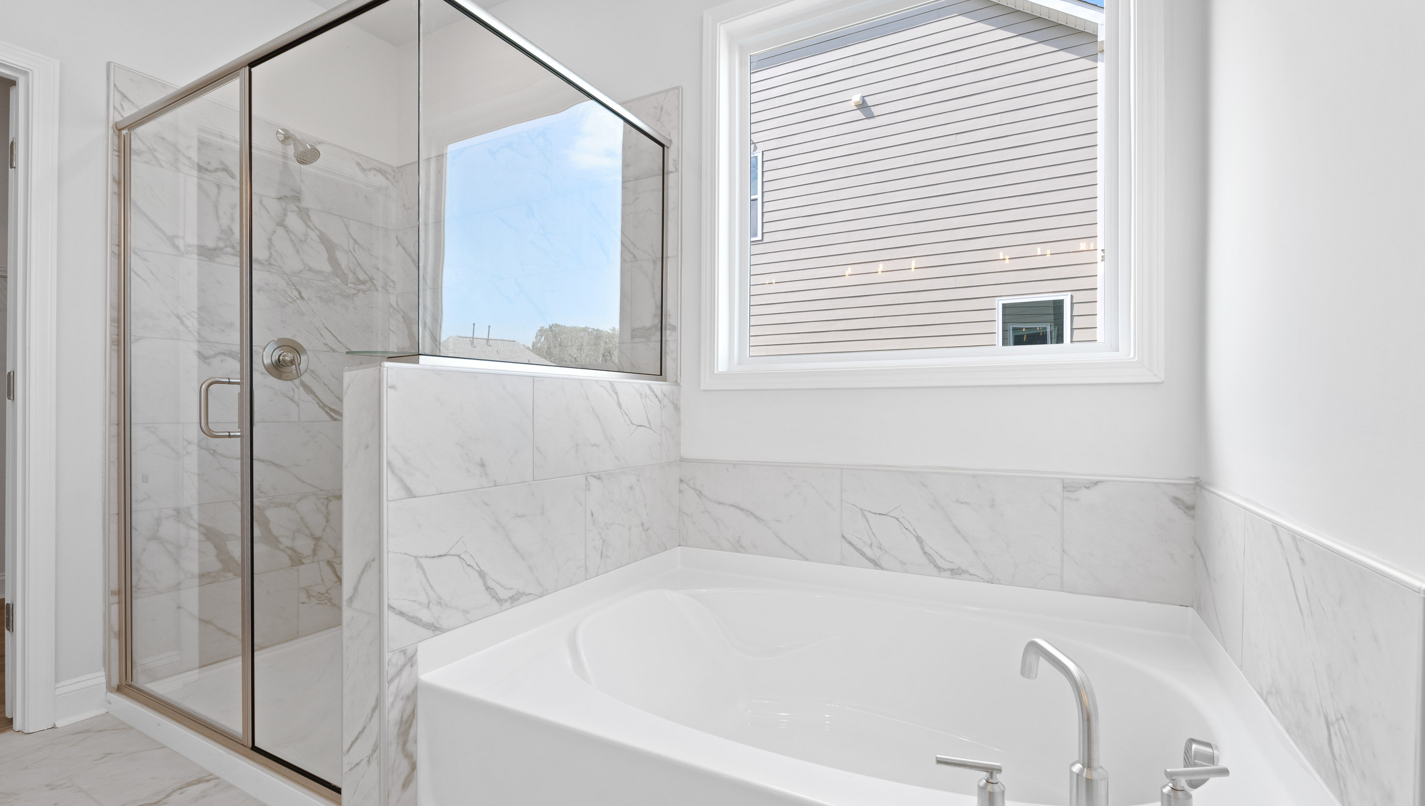 Primary bedroom hosts garden tub and walk-in shower.