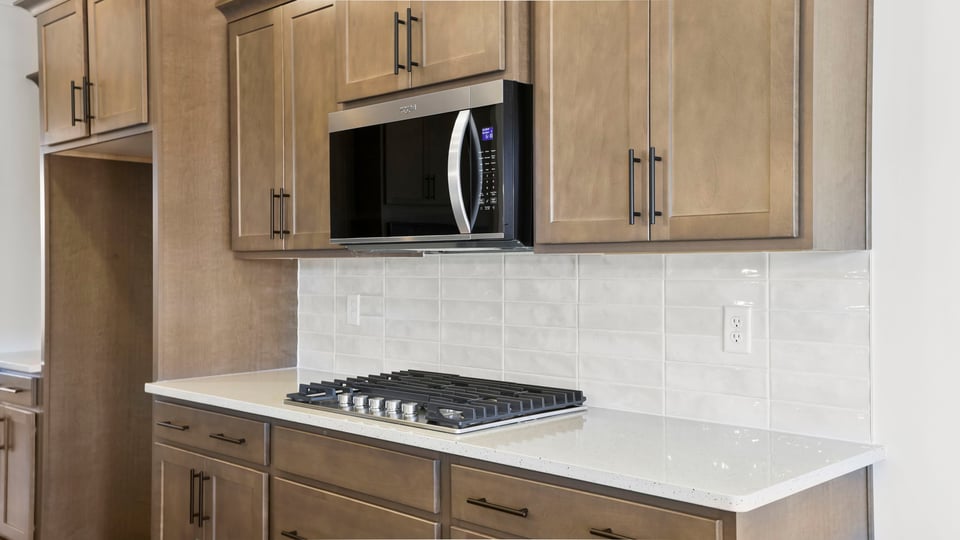 Kitchen features gas stovetop and built-in microwave.
