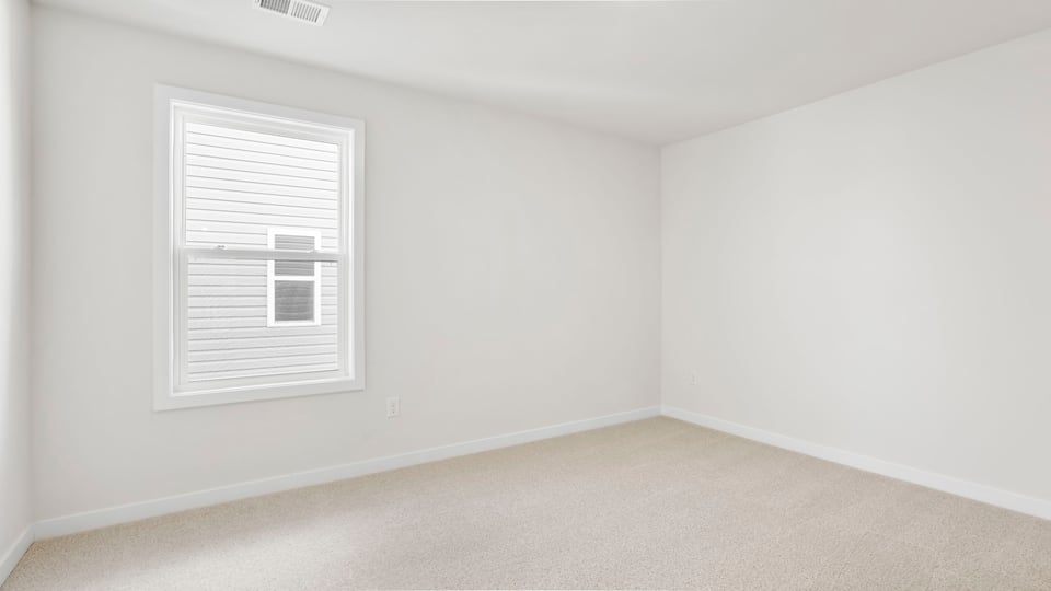 Bedroom with large window and carpet.