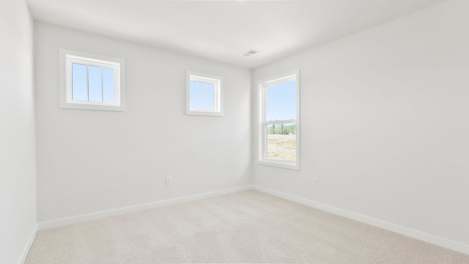 Bedroom with large window and carpet.