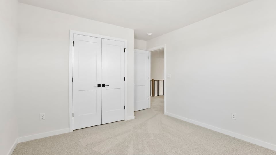 Bedroom with large window and carpet.