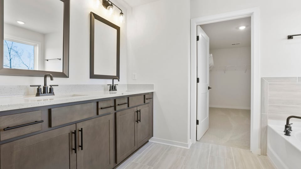 Primary bathroom with dual sink vanity and mirrors.