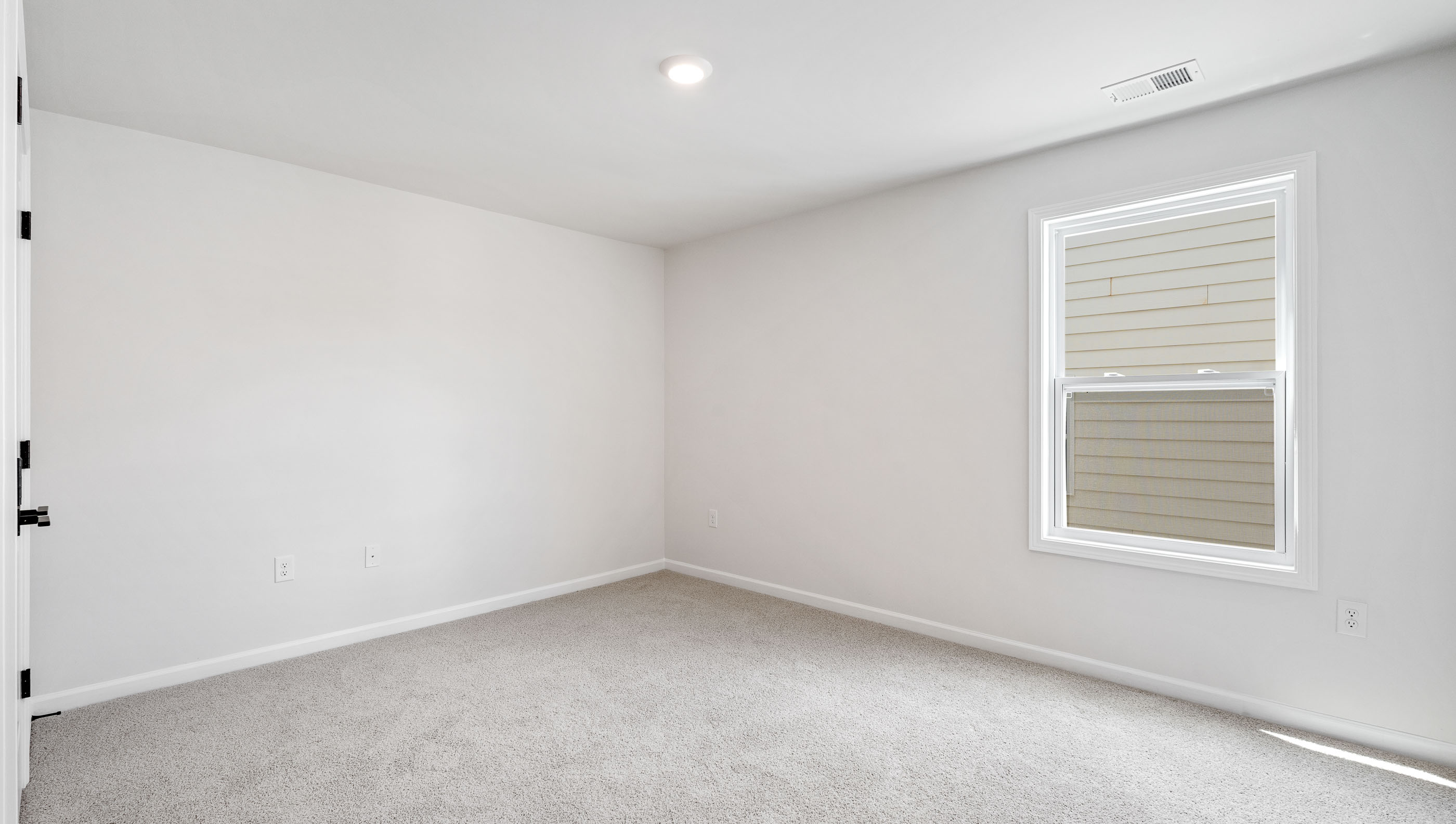 Bedroom with carpet and window.