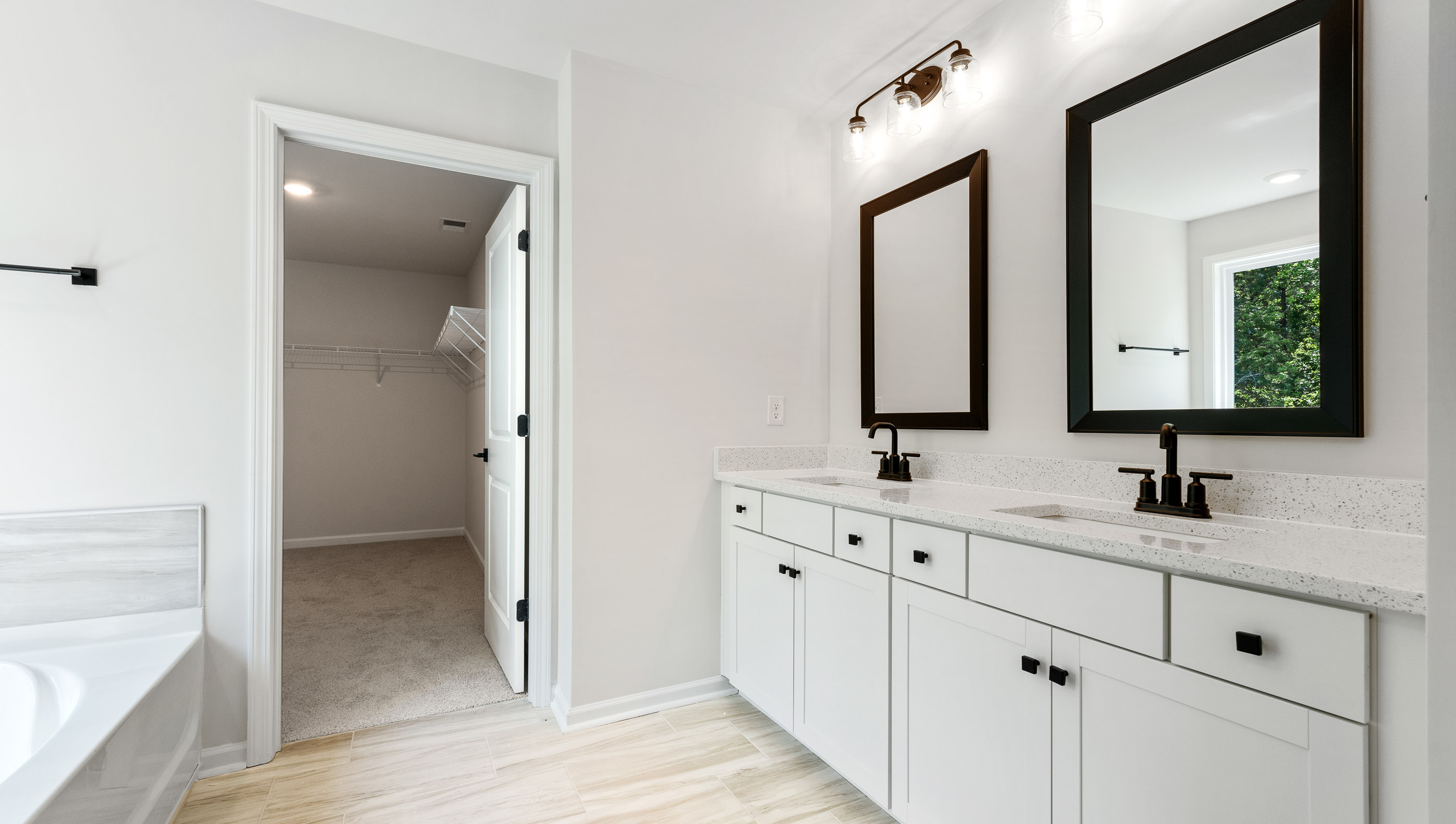 Bathroom with double vanity sink and tub.
