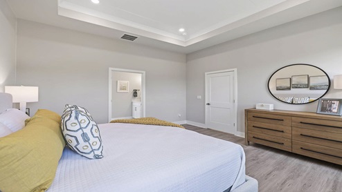 Primary bedroom with carpet and windows.