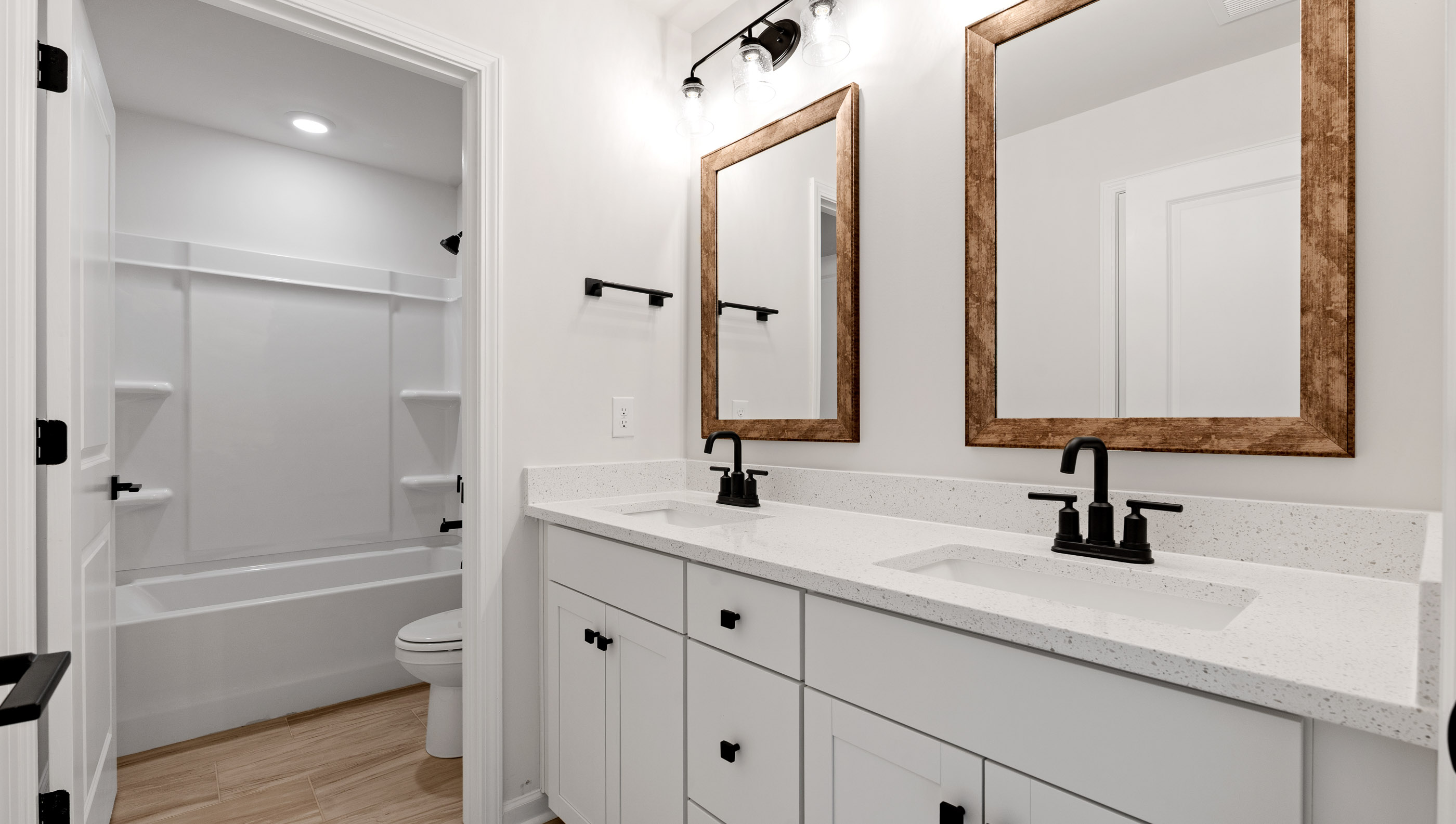 Hall bathroom with dual sink vanity and tub/shower.