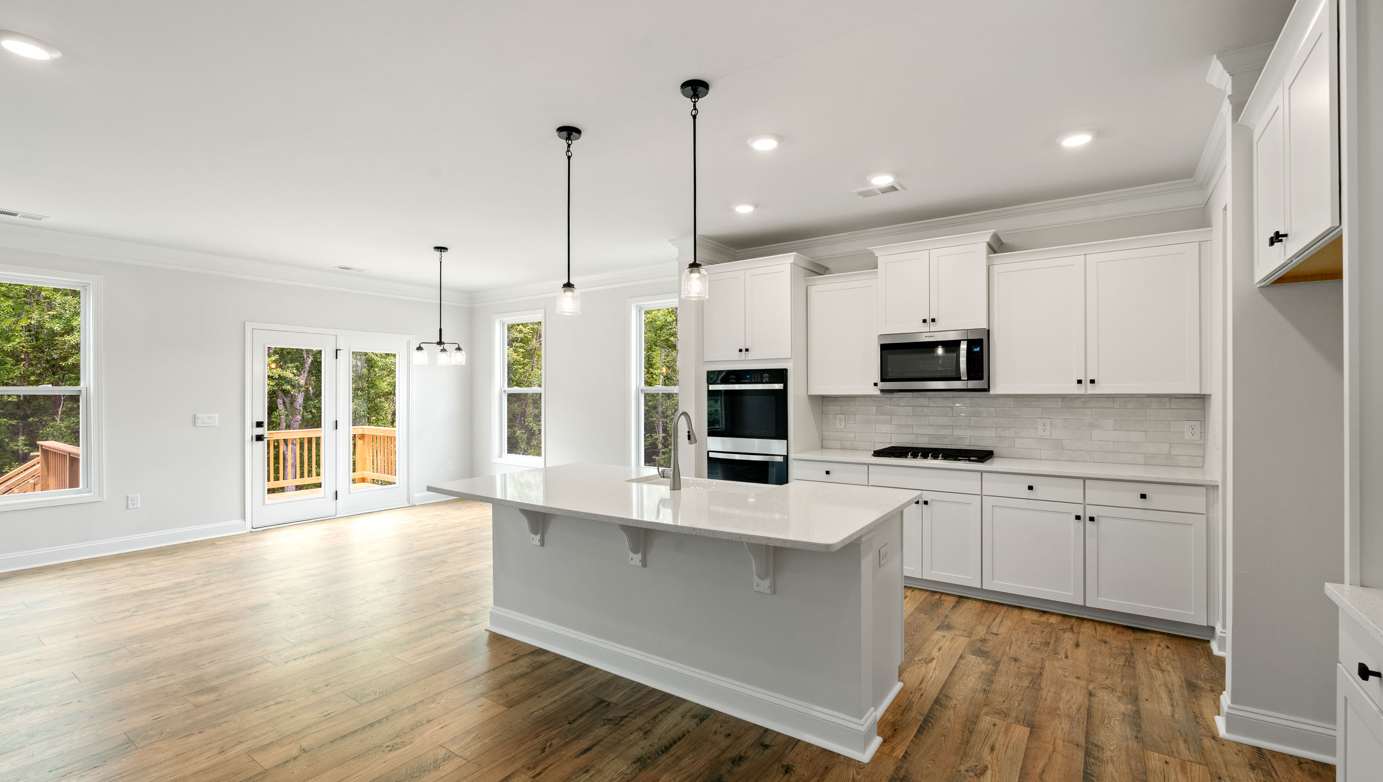 Kitchen with island, pendulum lighting and quartz countertops.
