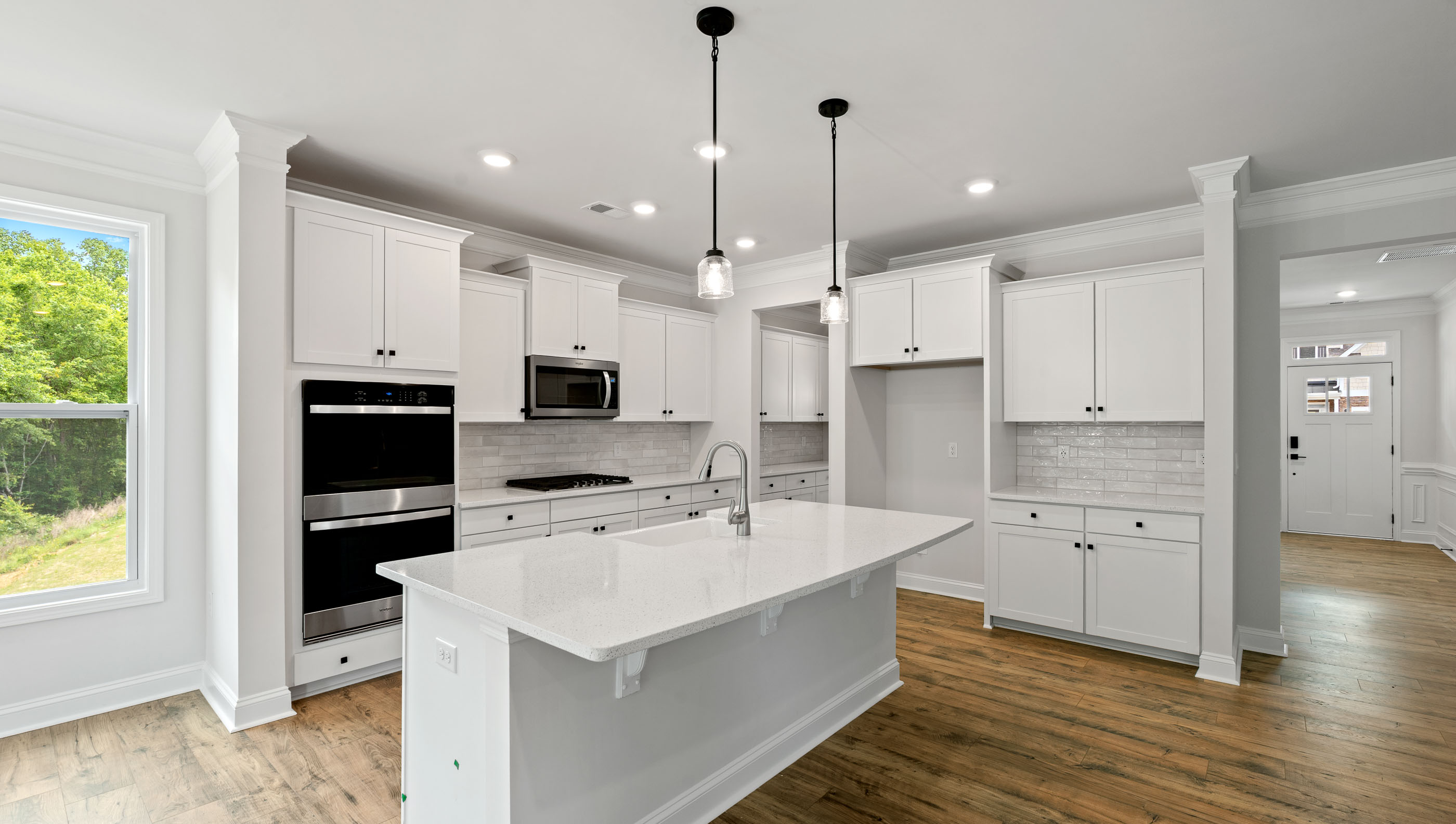 Kitchen with island, pendulum lighting and quartz countertops.