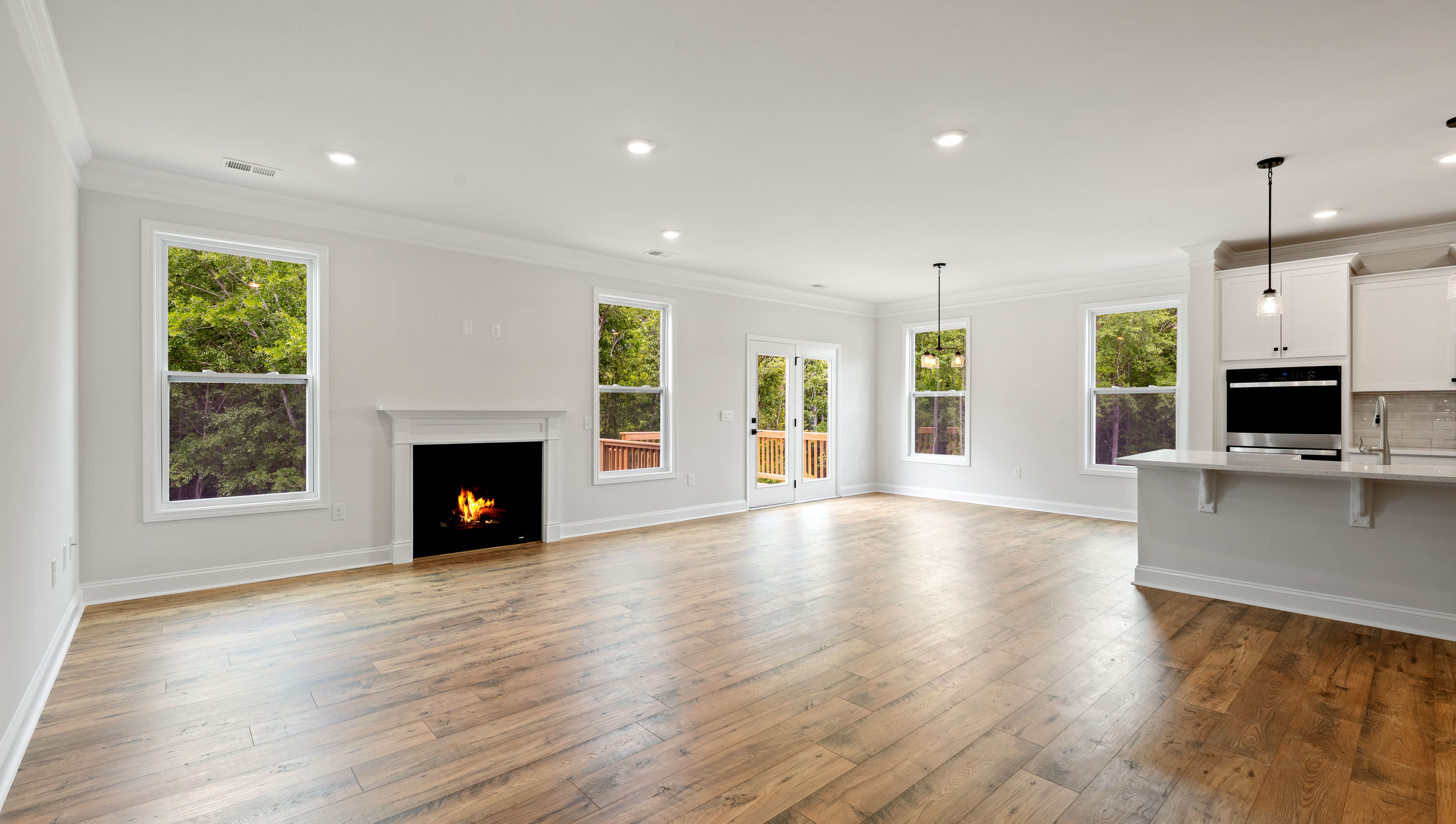 View of living area with gas log fireplace and lots of windows.