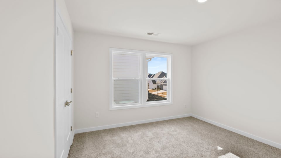 Bedroom with carpet and windows.