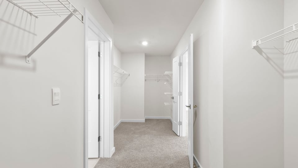Closet with carpet and shelf.