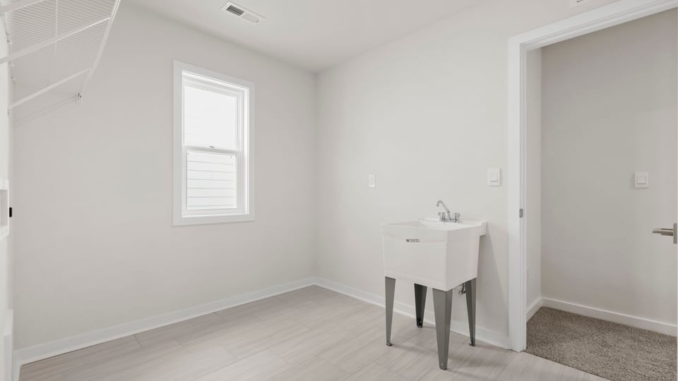 Laundry room with sink and window.
