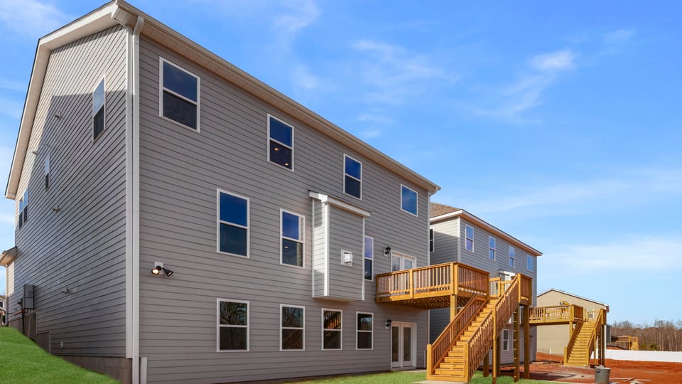 Back exterior with deck and large backyard.