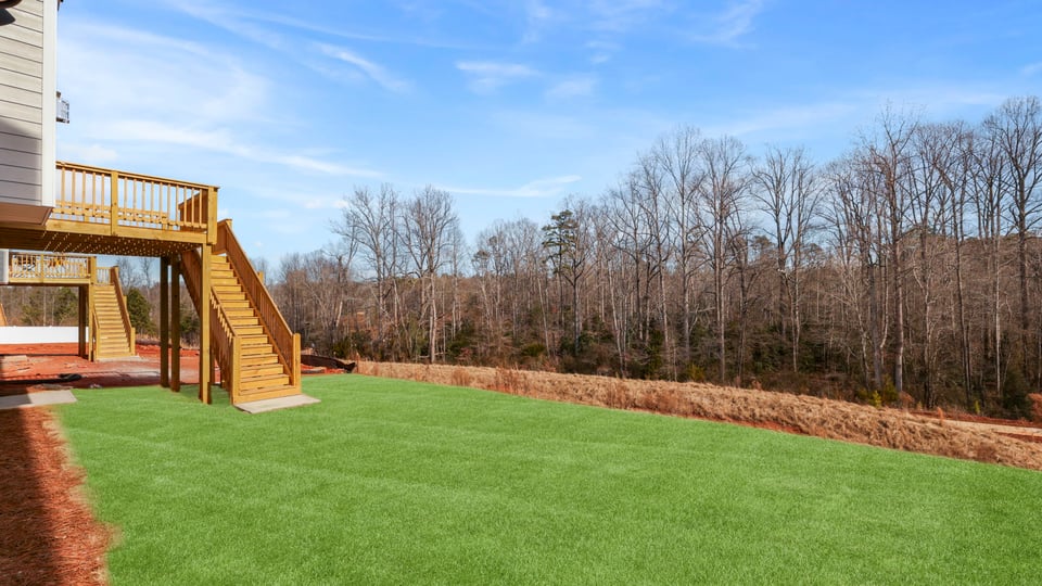 Back exterior with deck and large backyard.