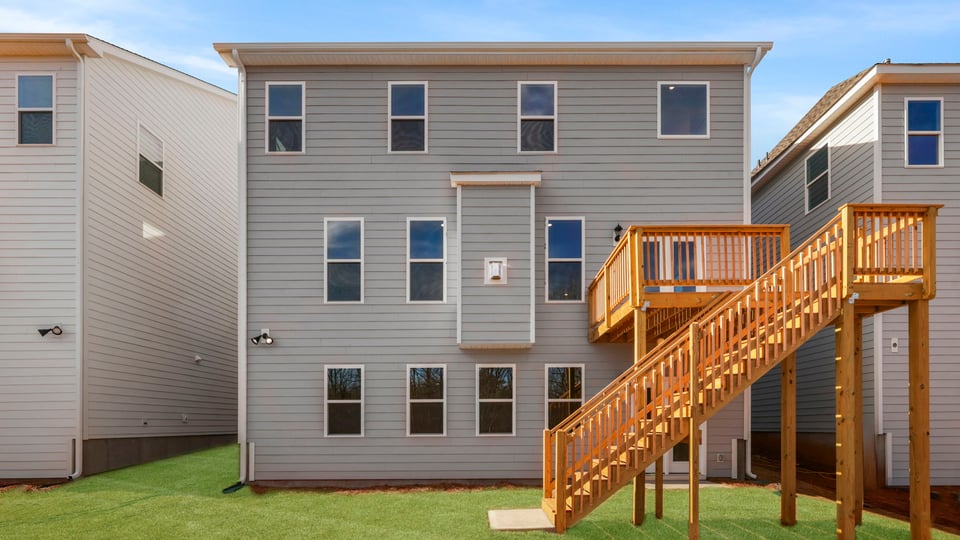 Back exterior with deck and large backyard.