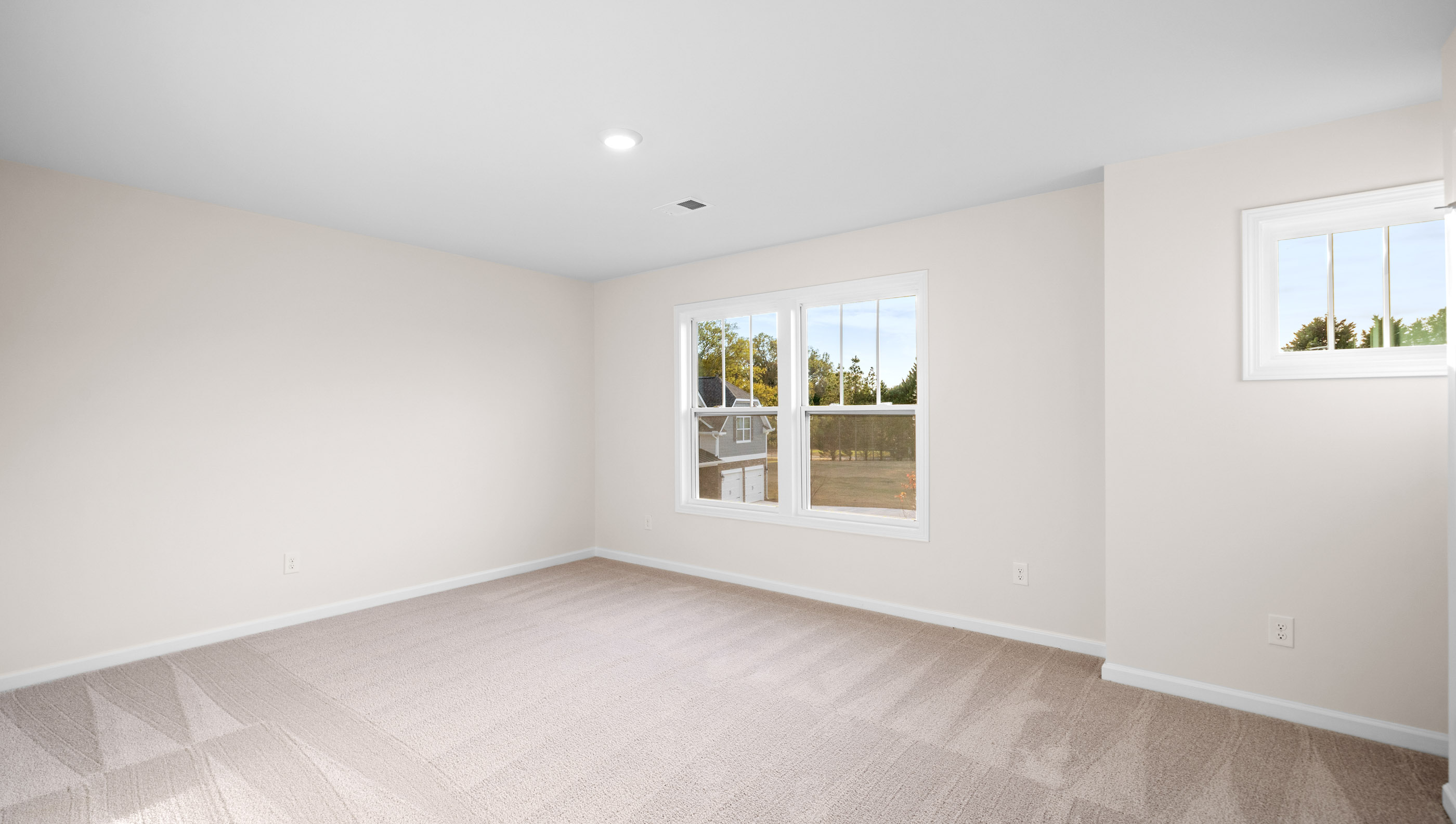 Bedroom with carpet and windows.