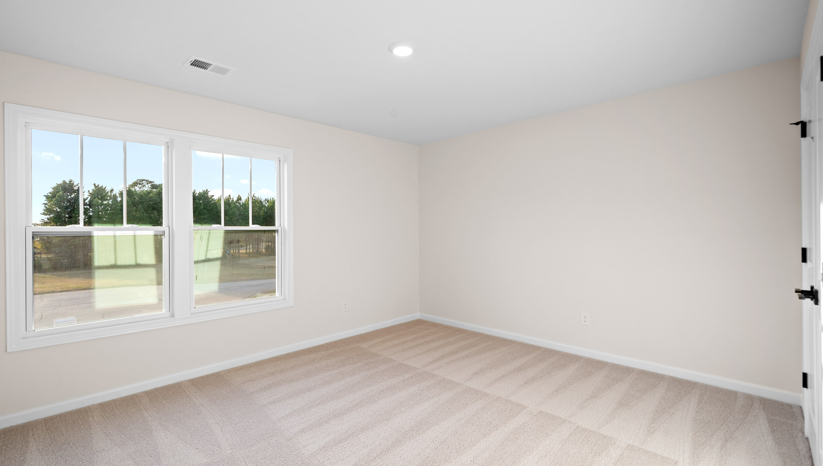 Bedroom with carpet and windows.
