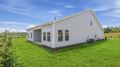 Back exterior of home with large backyard.