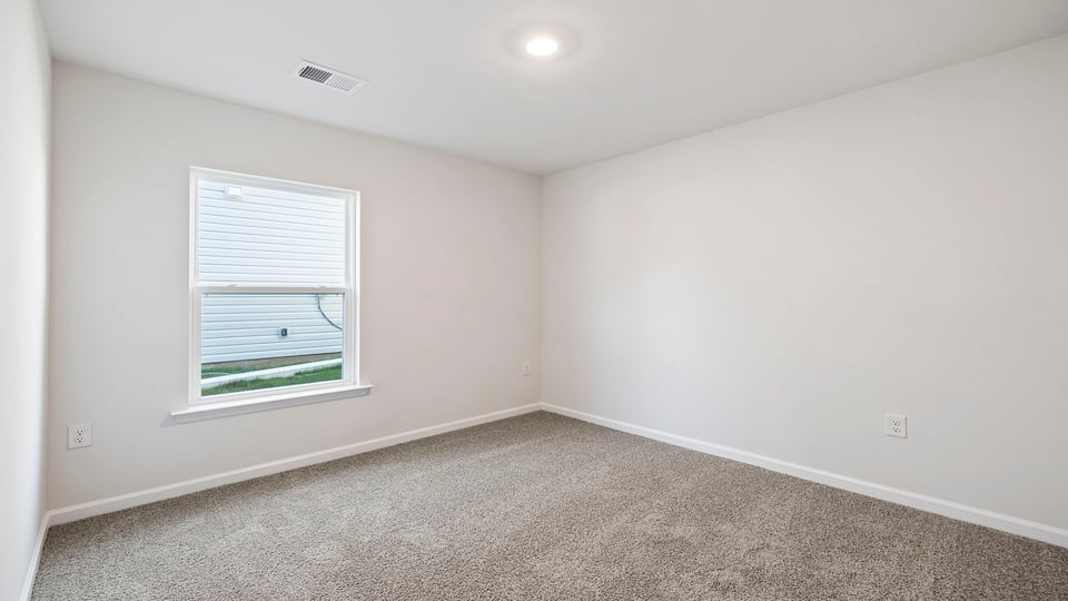 Bedroom with carpet and window.
