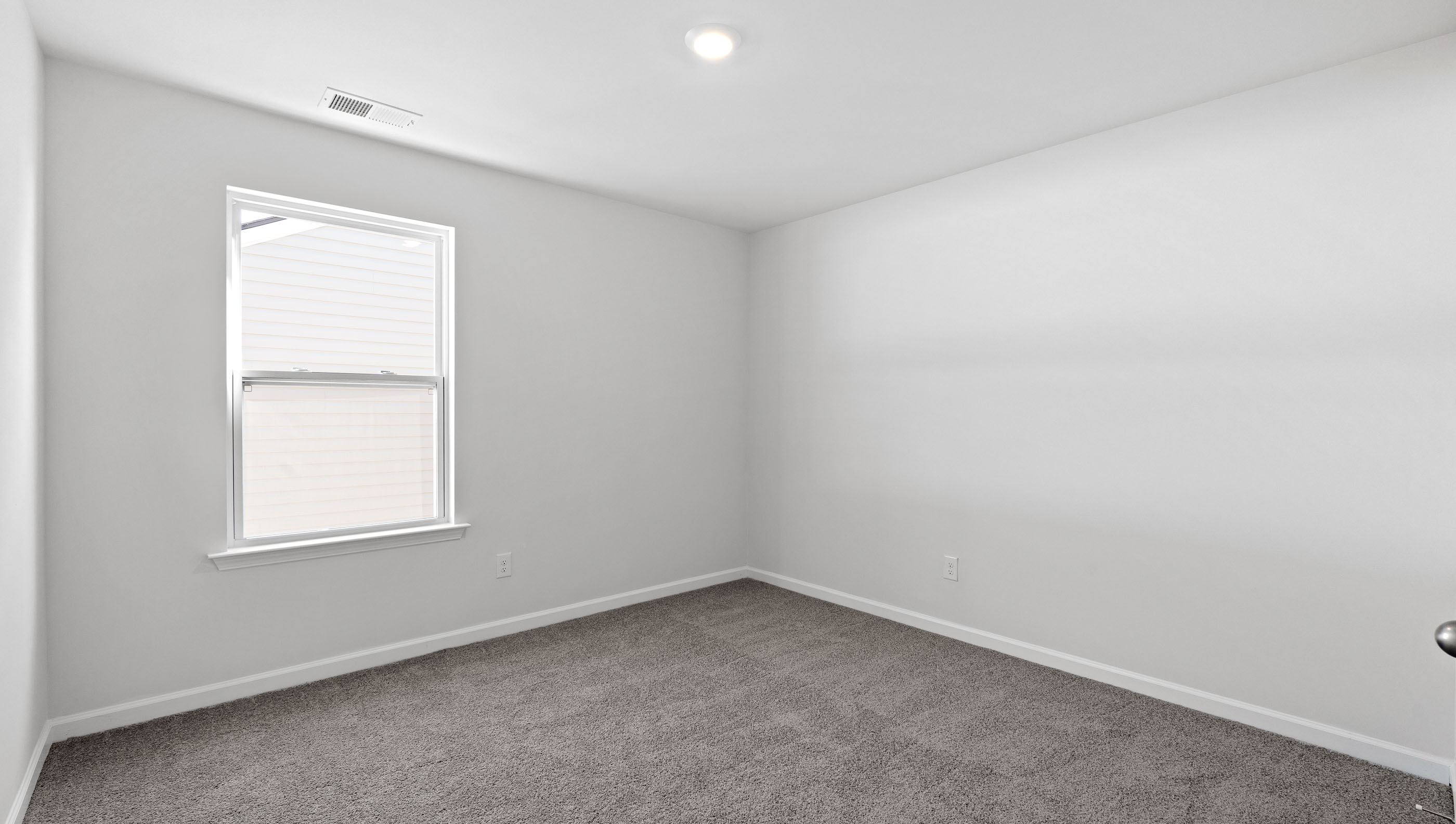 Bedroom with carpet and windows.