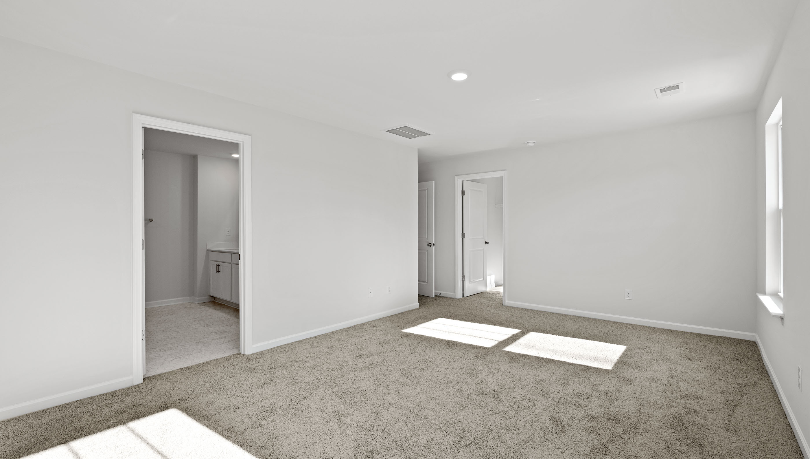 Bedroom with carpet and windows.