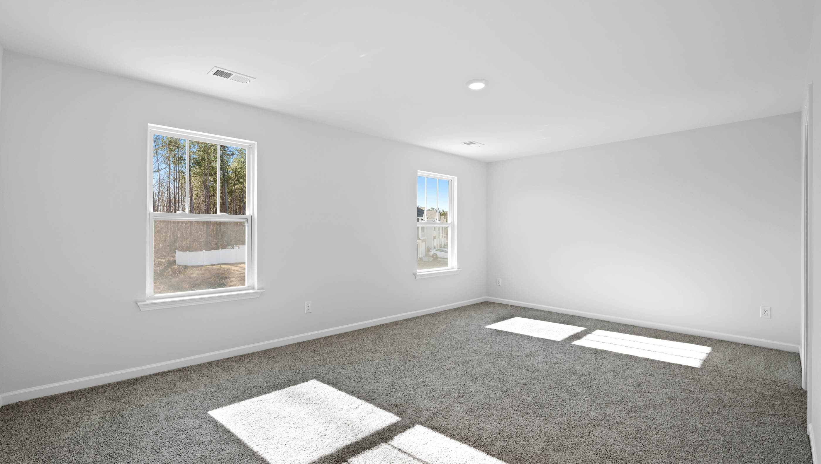 Bedroom with carpet and windows.