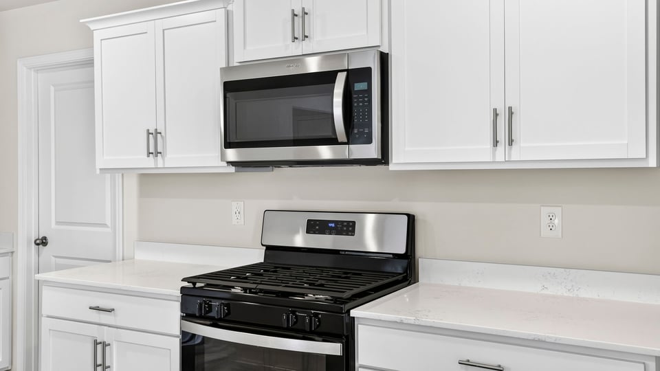 Close up of countertop, stove, and microwave