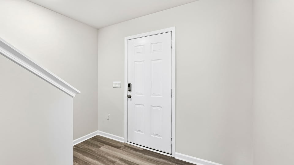 View of front door and bottom of stairs