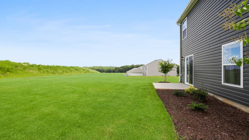 Back exterior of home with large backyard.