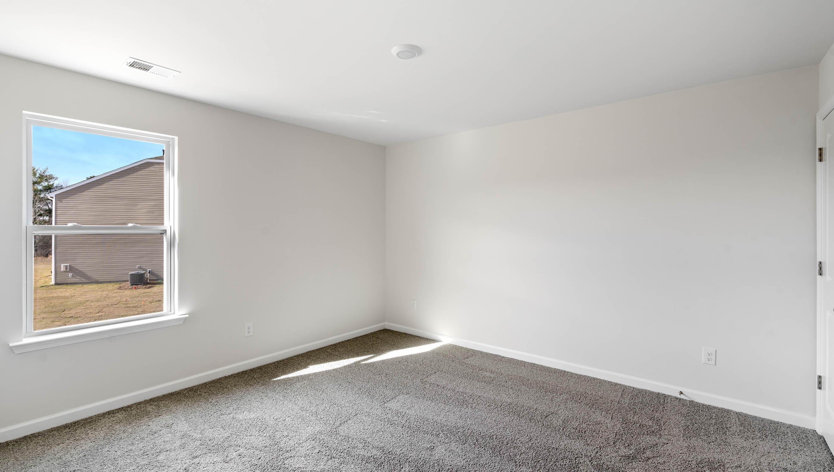 Bedroom with carpet and window.