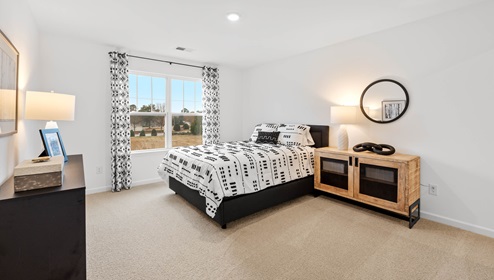 Bedroom with carpet and windows.