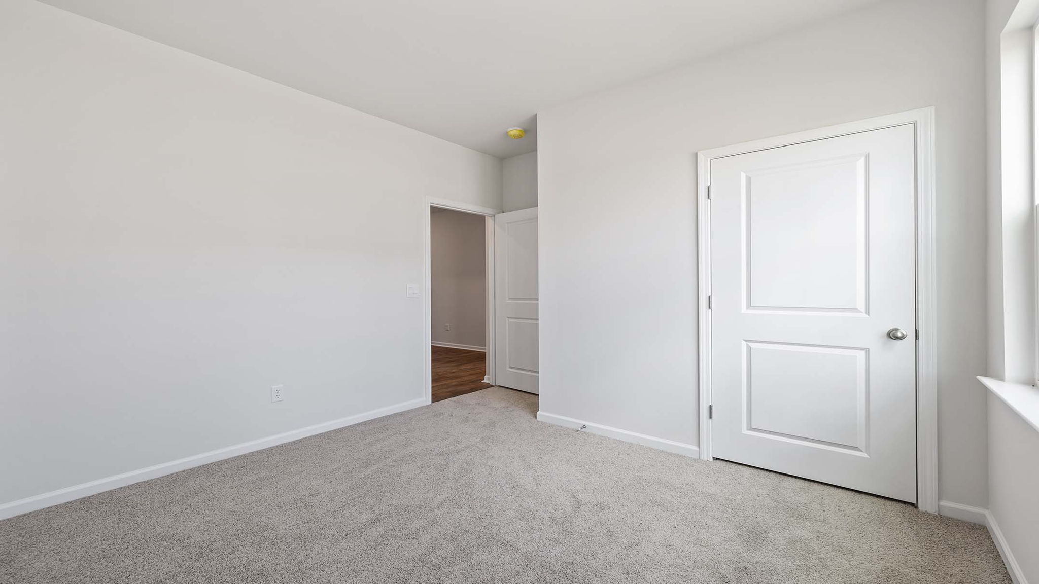 Bedroom with carpet and windows.