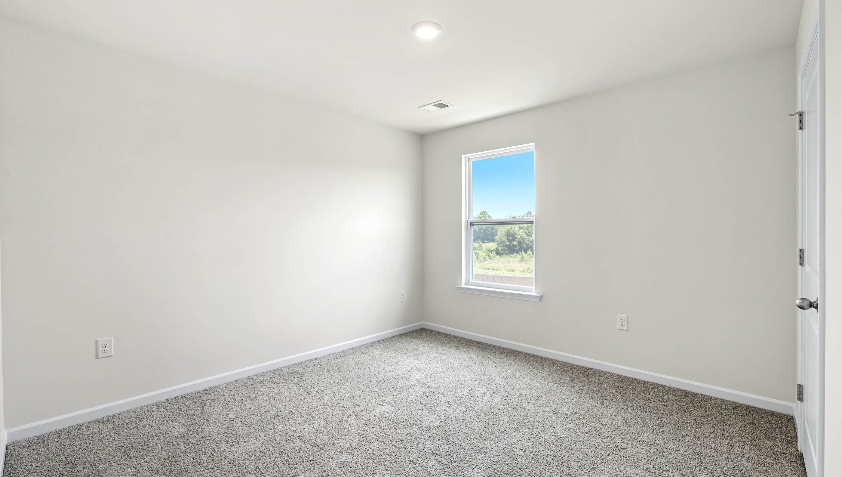 Bedroom with carpet and window.