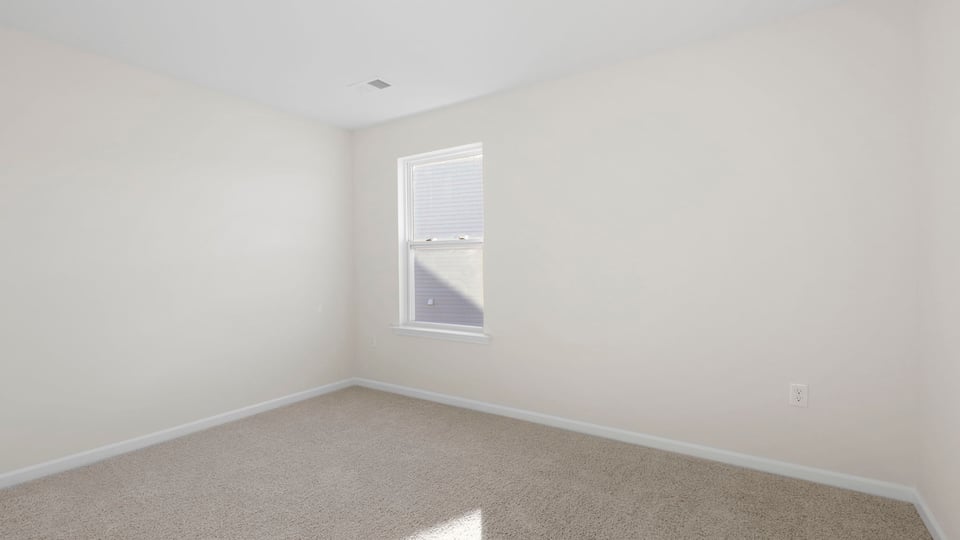 Bedroom with carpet and window.