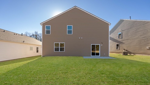 Back exterior of home with large backyard.